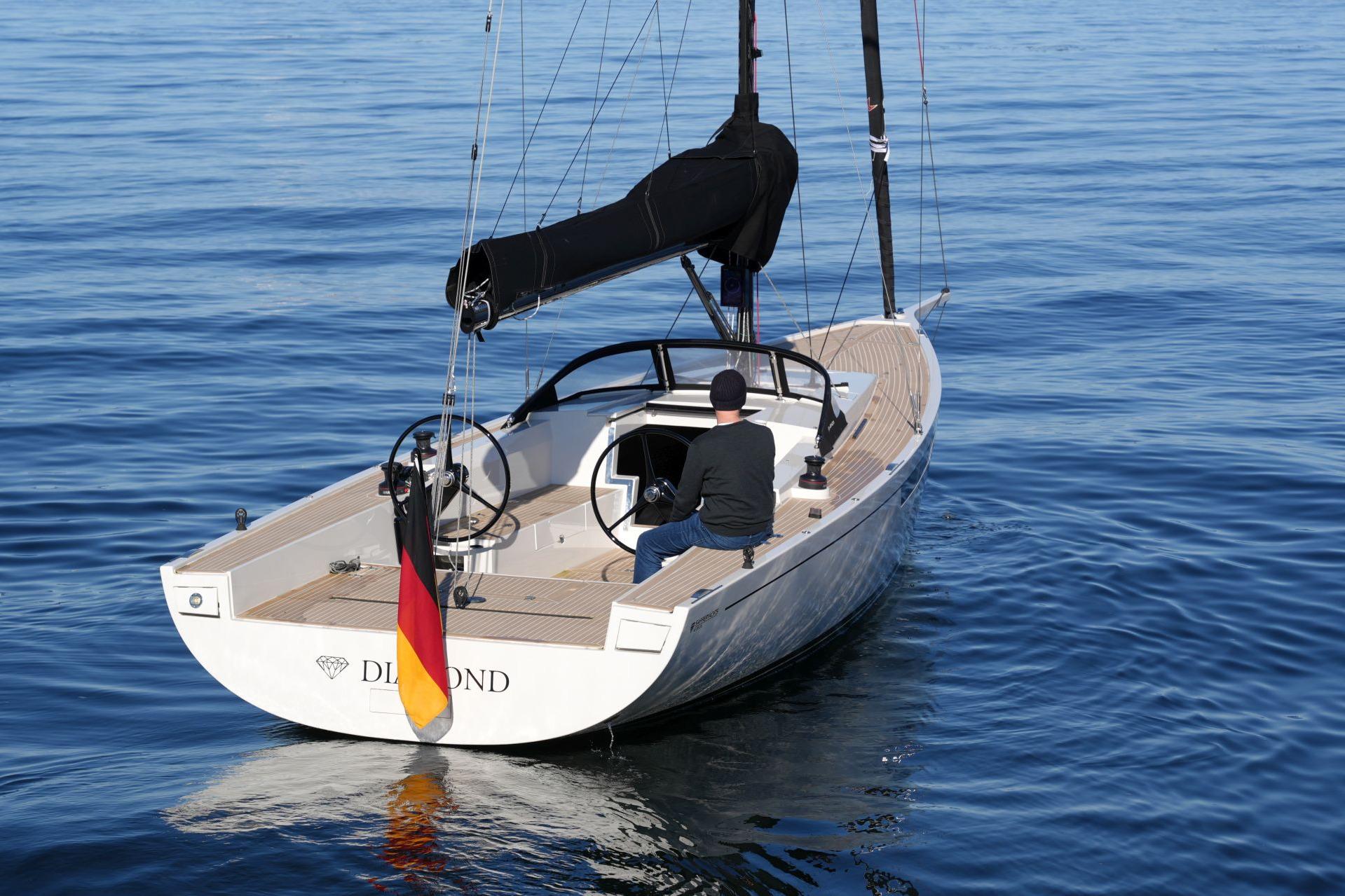 2023 Saffier SE 33 Life sailboat on calm blue water, rear view.