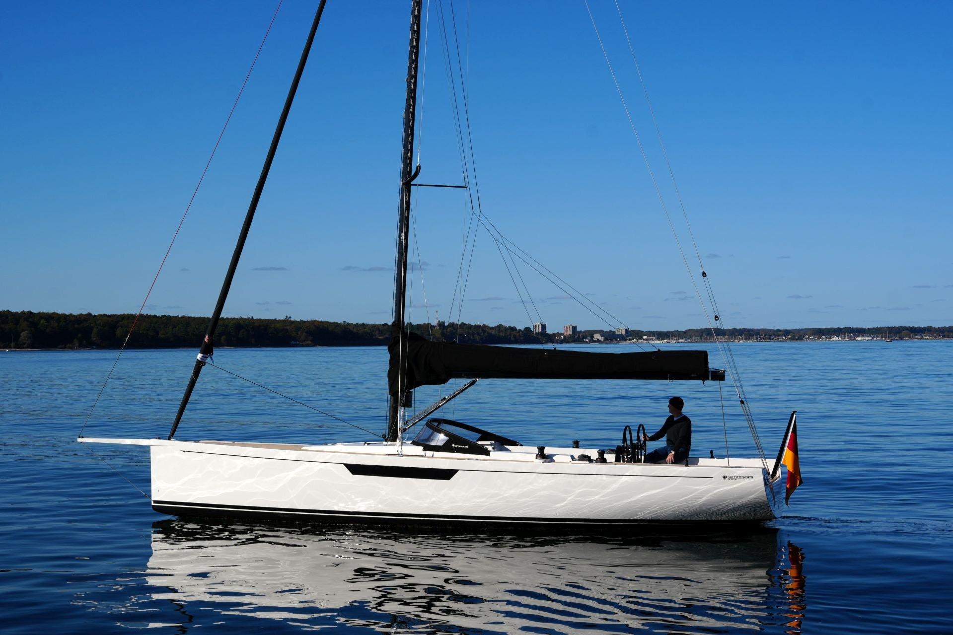 2023 Saffier SE 33 Life sailboat on calm water, clear blue sky background.