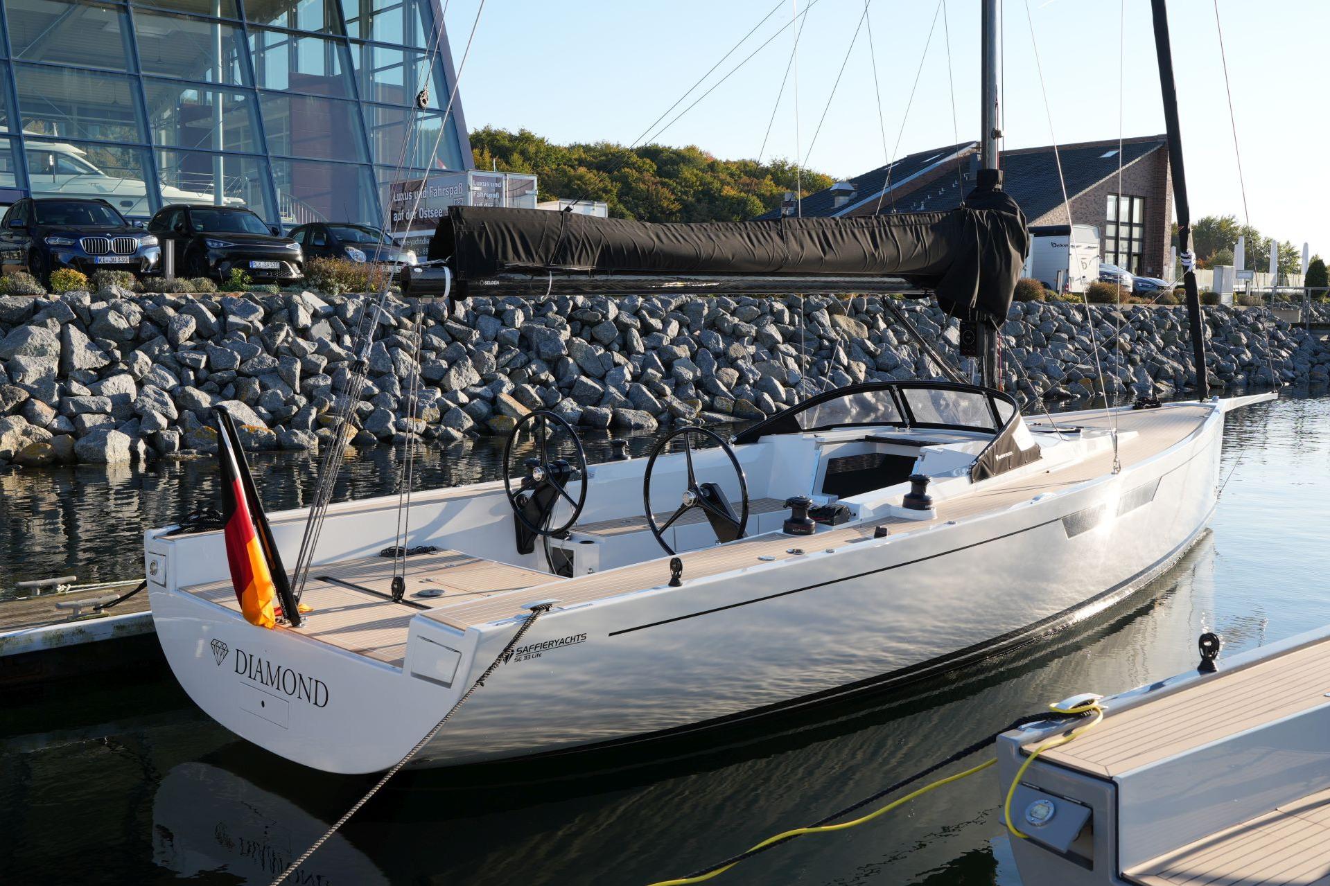 2023 Saffier SE 33 Life yacht docked at marina, sleek design, modern architecture backdrop.