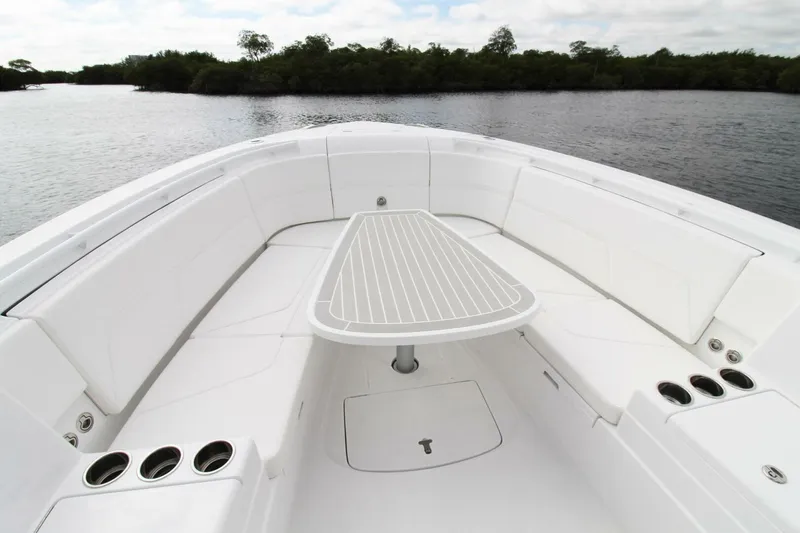  Yacht Photos Pics 2024 Intrepid 375 Nomad SE boat interior with seating and table on calm water.