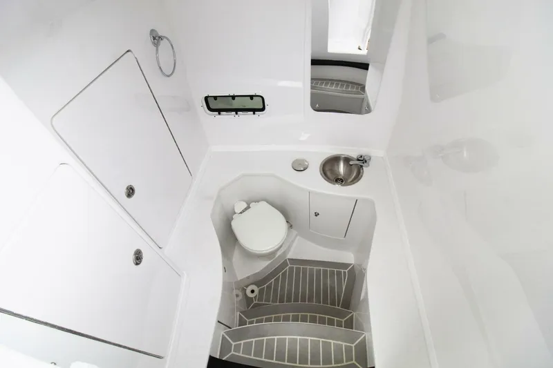 Yacht Photos Pics 2024 Intrepid 375 Nomad SE boat bathroom with toilet, sink, and storage compartments.