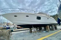 2007 Astondoa 53 Open yacht on dry dock, marina background, cloudy sky.