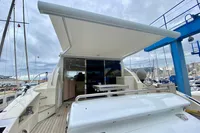 Astondoa 53 Open 2007 yacht with extended canopy in a marina setting.