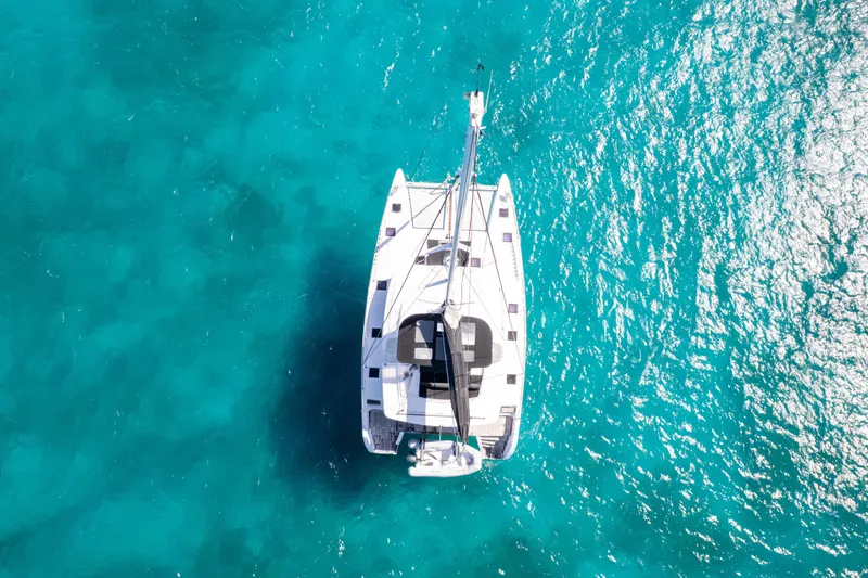  Yacht Photos Pics Aerial view of 2017 Lagoon 52 F catamaran on clear turquoise water.