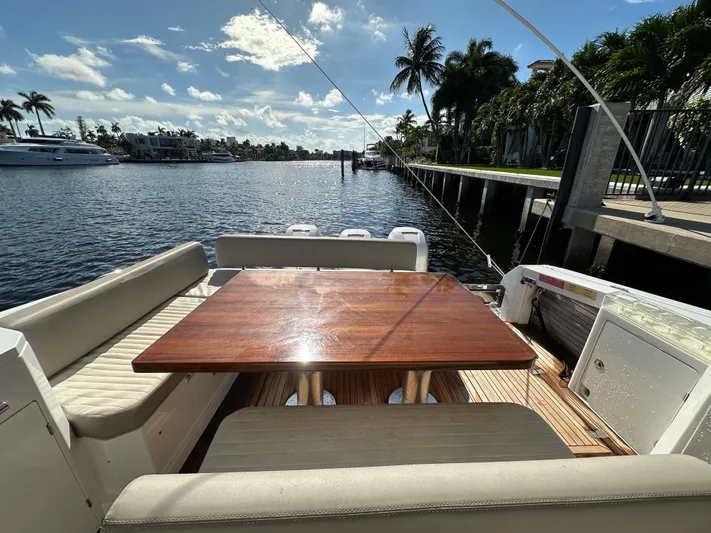  Yacht Photos Pics 2018 Azimut Verve 40 yacht deck with wooden table, docked by a scenic waterfront.