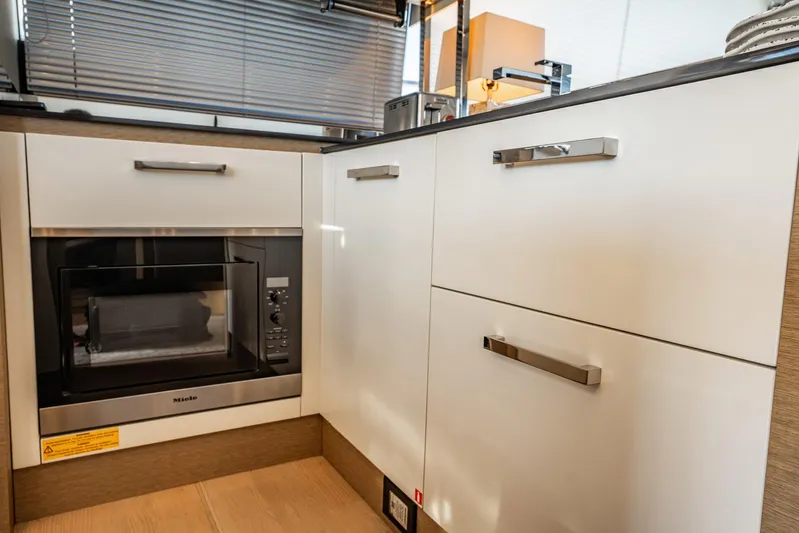 No Rush Yacht Photos Pics Modern kitchen interior on a 2018 Prestige 630 yacht, featuring sleek cabinetry and appliances.