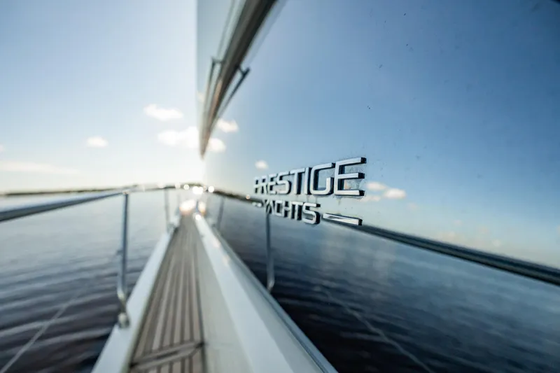 No Rush Yacht Photos Pics Side view of 2018 Prestige 630 yacht reflecting water and sky.
