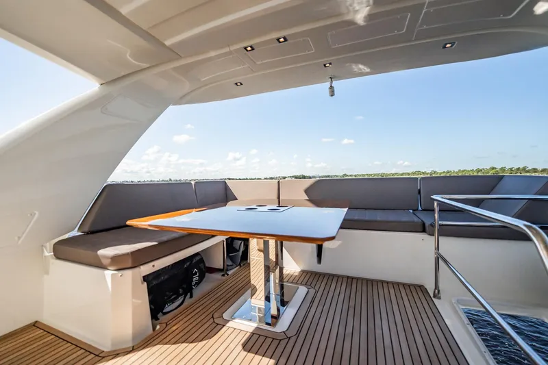 No Rush Yacht Photos Pics Luxurious 2018 Prestige 630 yacht deck with seating and table, overlooking serene waters.