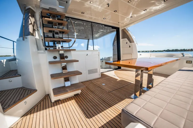 No Rush Yacht Photos Pics Luxurious 2018 Prestige 630 yacht interior with wooden deck, modern seating, and elegant staircase.