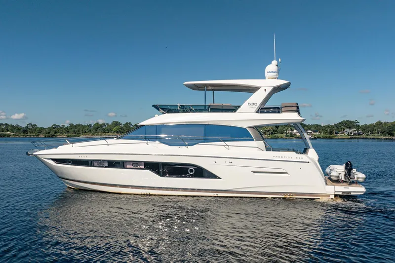 No Rush Yacht Photos Pics 2018 Prestige 630 yacht cruising on a serene lake under a clear blue sky.