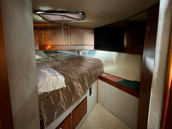 On Course Yacht Photos Pics 1986 Egg Harbor 41 Convertible cabin interior with bed, wooden cabinets, and cozy lighting.