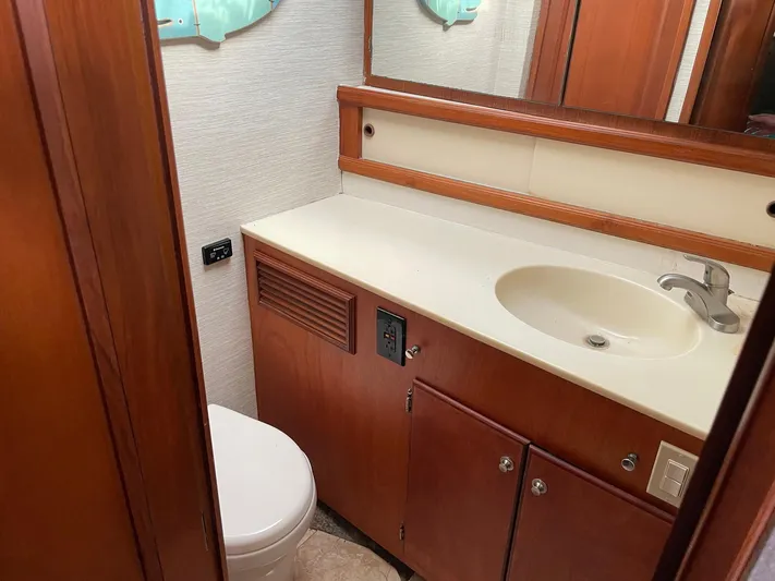 On Course Yacht Photos Pics 1986 Egg Harbor 41 Convertible yacht bathroom with sink, toilet, and wooden cabinetry.