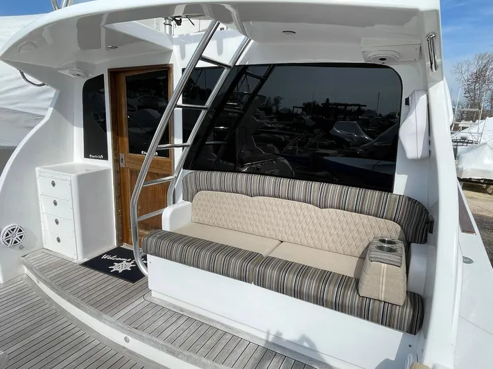 On Course Yacht Photos Pics 1986 Egg Harbor 41 Convertible yacht with striped seating and wooden door on deck.