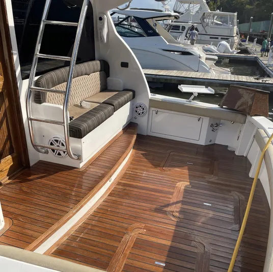 On Course Yacht Photos Pics 1986 Egg Harbor 41 Convertible yacht with wooden deck and seating area at marina.