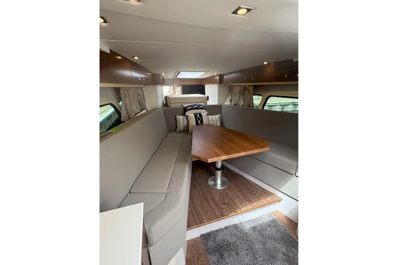  Yacht Photos Pics Luxurious interior of 2017 Cruisers Yachts 39 Express Coupe with elegant seating and wooden table.
