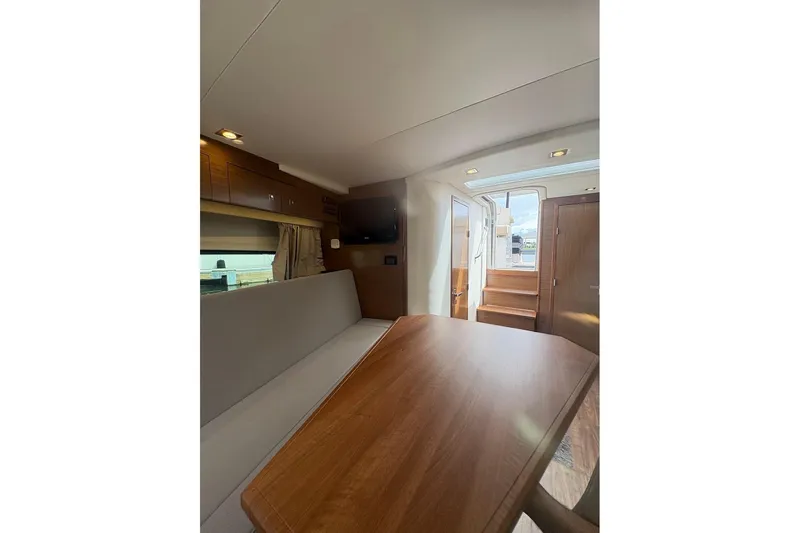  Yacht Photos Pics Interior of 2017 Cruisers Yachts 39 Express Coupe, featuring a cozy dining area and wooden finishes.