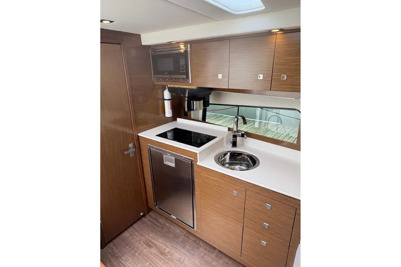  Yacht Photos Pics 2017 Cruisers Yachts 39 Express Coupe kitchen with modern appliances and wood cabinetry.