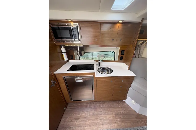  Yacht Photos Pics 2017 Cruisers Yachts 39 Express Coupe kitchen with modern appliances and wood cabinetry.
