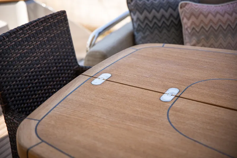 Tyche Yacht Photos Pics Wooden table and wicker chair on 2019 Monte Carlo Yachts MCY 76.