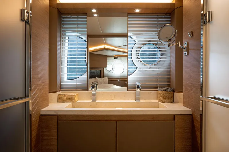 Tyche Yacht Photos Pics Luxurious bathroom interior of 2019 Monte Carlo Yachts MCY 76 with modern fixtures and porthole window.