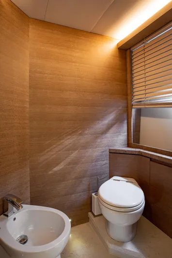 Tyche Yacht Photos Pics Luxurious bathroom on 2019 Monte Carlo Yachts MCY 76 with modern fixtures and wooden accents.