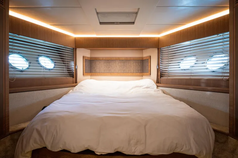 Tyche Yacht Photos Pics Luxurious bedroom interior of 2019 Monte Carlo Yachts MCY 76 with elegant wood finishes.