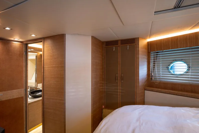 Tyche Yacht Photos Pics Luxurious interior of 2019 Monte Carlo Yachts MCY 76 with wood finishes and porthole window.