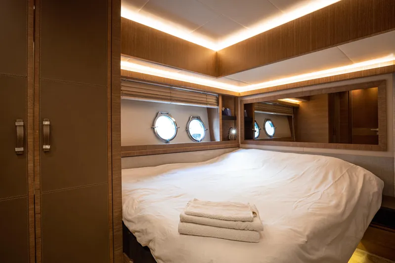 Tyche Yacht Photos Pics Luxurious bedroom interior of 2019 Monte Carlo Yachts MCY 76 with elegant wood finishes.