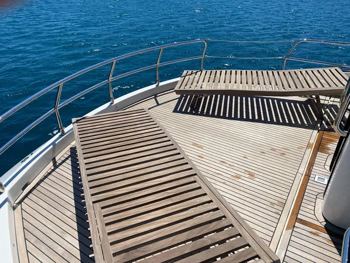 Tyche Yacht Photos Pics Luxurious deck of 2019 Monte Carlo Yachts MCY 76 with wooden loungers and ocean view.
