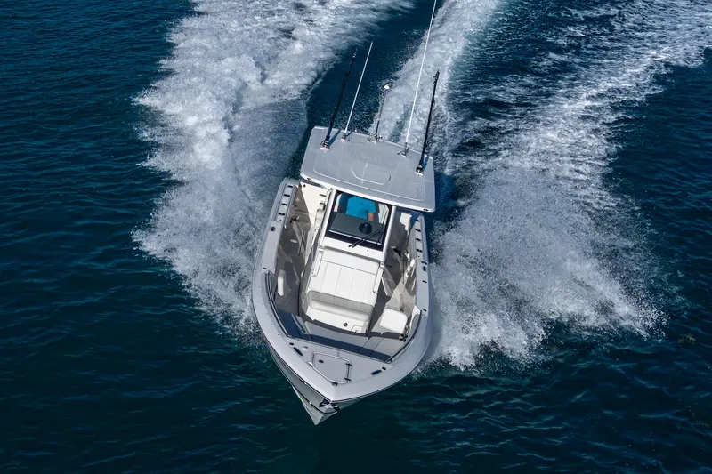 @c Yacht Photos Pics 2022 Pursuit S 268 Sport boat cruising on open water, aerial view.