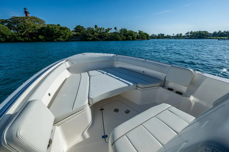 @c Yacht Photos Pics 2022 Pursuit S 268 Sport boat interior with seating, on a serene blue lake.