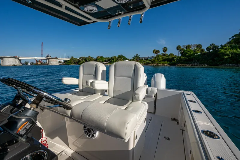 @c Yacht Photos Pics 2022 Pursuit S 268 Sport boat interior with white seating, steering wheel, and scenic water view.