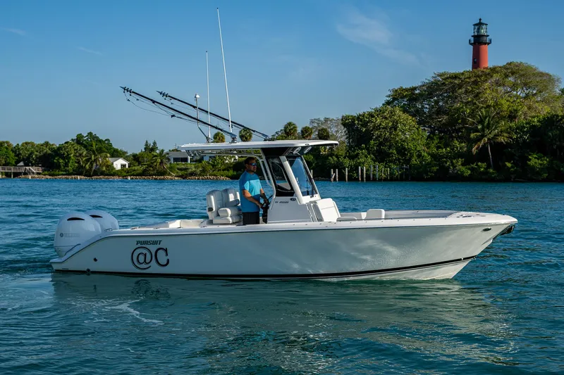 @c Yacht Photos Pics 2022 Pursuit S 268 Sport boat on water near lighthouse, clear sky.