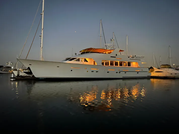 Entrepeneur Yacht Photos Pics Luxurious 1992 Christensen motor yacht illuminated at dusk, reflecting on calm water.