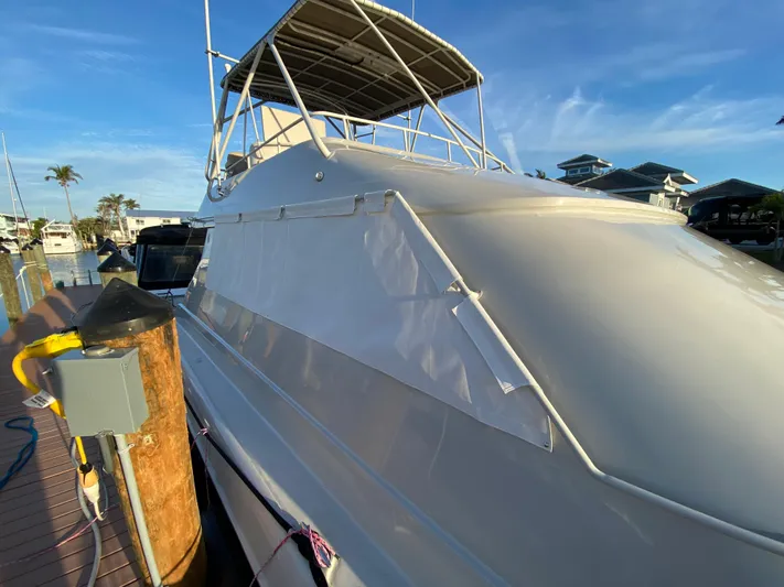  Yacht Photos Pics 1995 Mares 58 Power Cat docked, featuring sleek white exterior and covered upper deck.