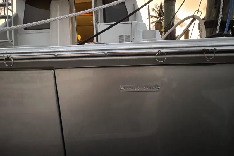  Yacht Photos Pics Side view of a 1995 Mares 58 Power Catamaran docked, showing sleek metallic finish.