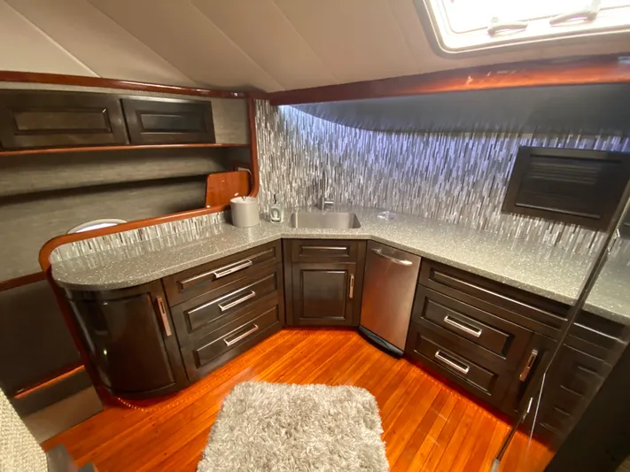  Yacht Photos Pics Luxurious kitchen interior of 1995 Mares 58 Power Cat yacht with modern cabinetry and wood flooring.