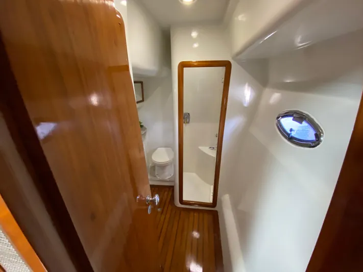  Yacht Photos Pics Bathroom interior of 1995 Mares 58 Power Cat with wooden door and porthole window.