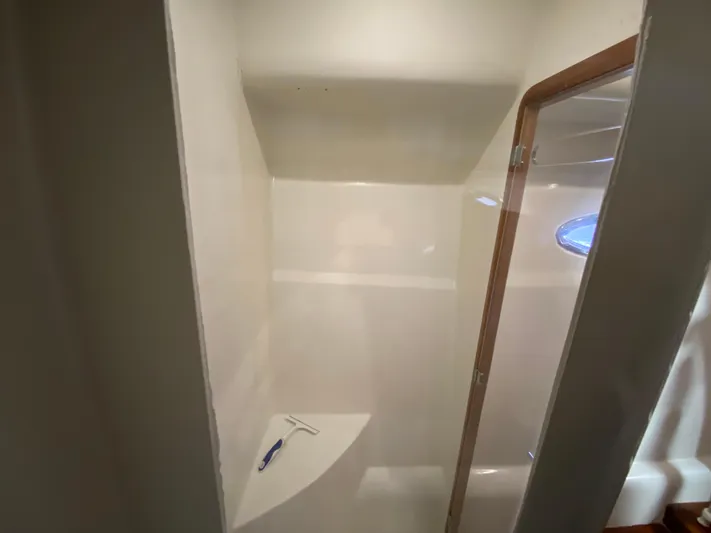  Yacht Photos Pics Shower area inside a 1995 Mares 58 Power Cat, featuring a glass door and white interior.