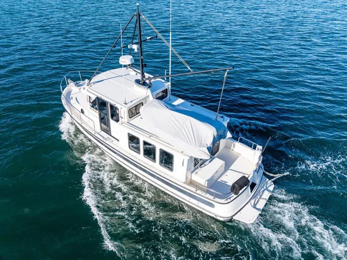 Naukati II Yacht Photos Pics Nordic Tug 32, 2000 model, cruising on open water, aerial view.