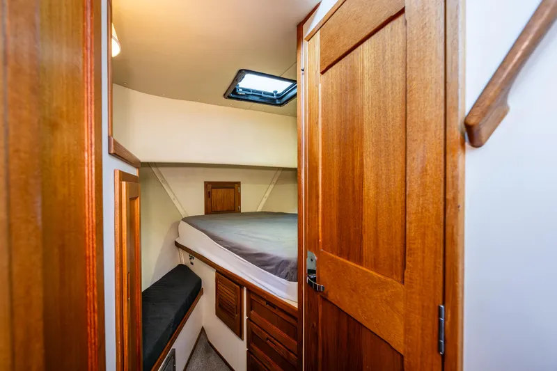 Naukati II Yacht Photos Pics Cozy cabin interior of 2000 Nordic Tug 32 with wooden door and bed.