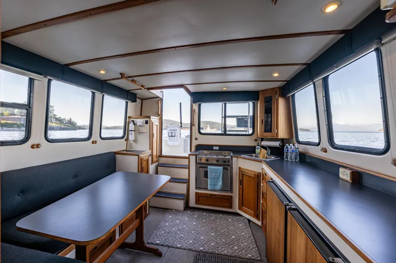 Naukati II Yacht Photos Pics Interior of 2000 Nordic Tug 32, featuring kitchen and dining area with scenic window views.
