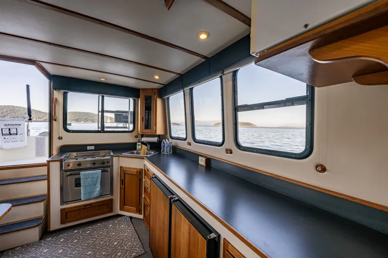 Naukati II Yacht Photos Pics Interior of a 2000 Nordic Tug 32 boat with kitchen and scenic water view.