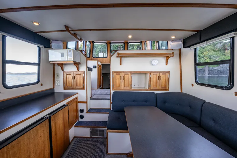 Naukati II Yacht Photos Pics Interior of a 2000 Nordic Tug 32, featuring a cozy dining area and wooden cabinetry.