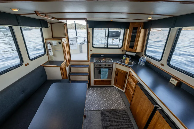 Naukati II Yacht Photos Pics Interior of 2000 Nordic Tug 32, featuring kitchen and dining area with scenic water views.