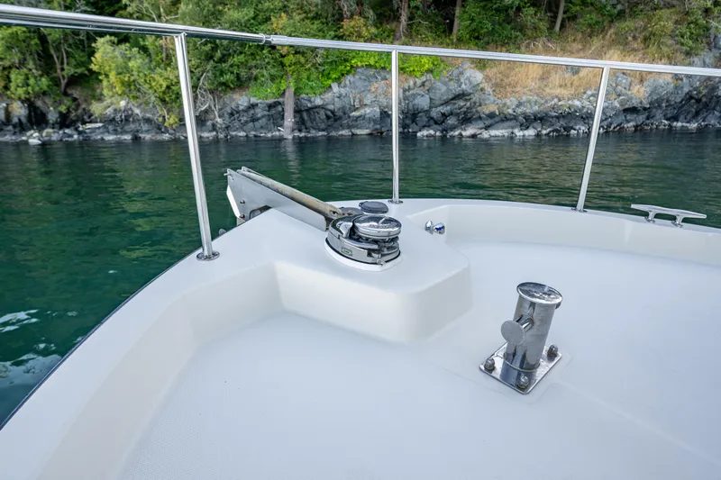 Naukati II Yacht Photos Pics Nordic Tug 32 boat deck with railing, near rocky shoreline, 2000 model.