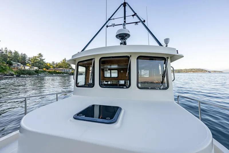 Naukati II Yacht Photos Pics 2000 Nordic Tug 32 on calm water, showcasing cabin and deck.