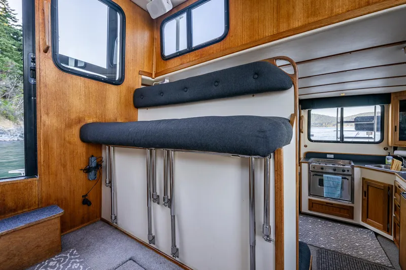 Naukati II Yacht Photos Pics Interior of a 2000 Nordic Tug 32 boat with wooden paneling and compact kitchen.