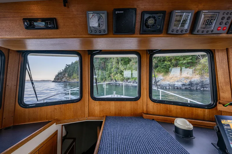 Naukati II Yacht Photos Pics Interior view of a 2000 Nordic Tug 32, showcasing navigation instruments and scenic windows.