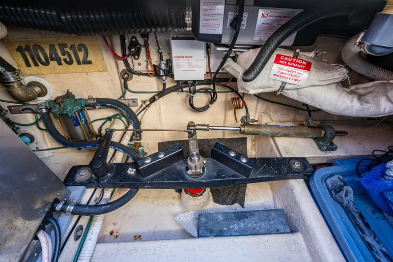 Naukati II Yacht Photos Pics Engine compartment of a 2000 Nordic Tug 32, showing mechanical components and warning labels.